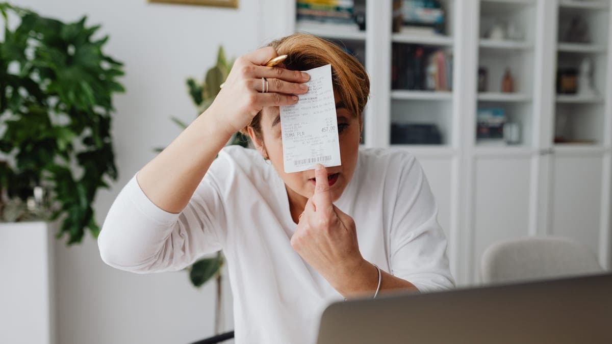 A business owner checking VAT invoices and figures on a laptop at a desk