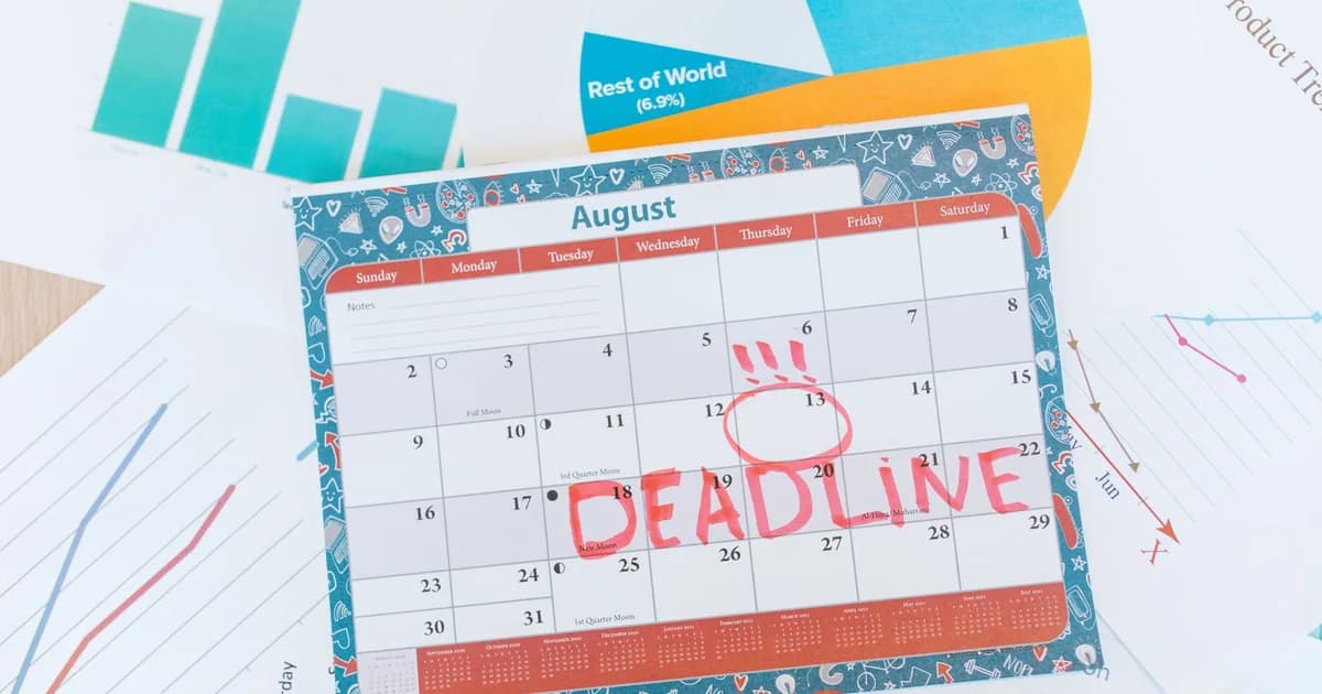 Vibrant August calendar on a desk with deadline marked in red, surrounded by graphs and charts.